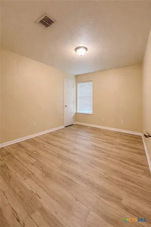a view of room with wooden floor and cabinet