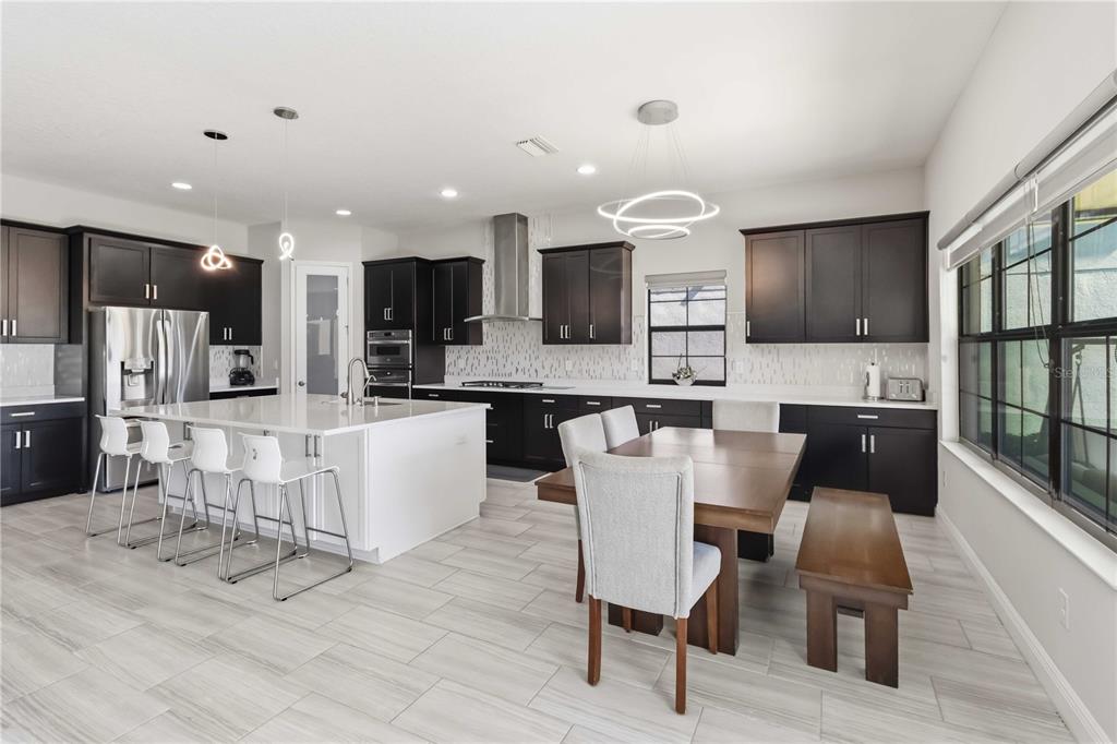 805 Viscount Street Brandon, FL 33511 - Photo 7 of 46 a view of kitchen with stainless steel appliances refrigerator stove dining table and chairs