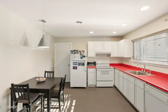 a kitchen that has a lot of cabinets and wooden floor