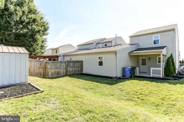 a view of a house with backyard and tree