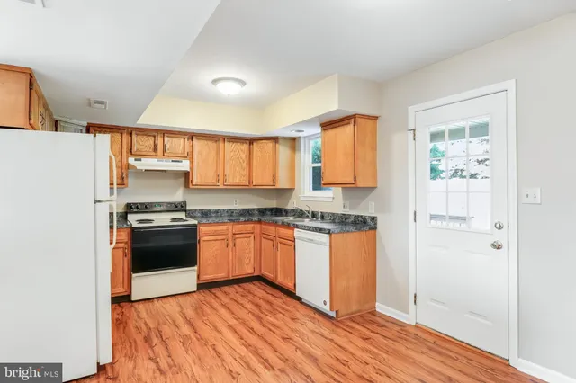 a kitchen with granite countertop wooden floors and stainless steel appliances
