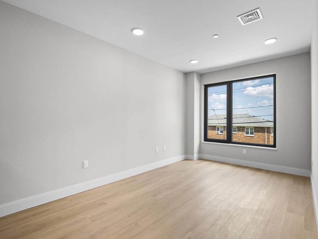 249 Corey Road, Unit 105 Boston, MA 02135 - Photo 19 of 39 a view of an empty room with a window