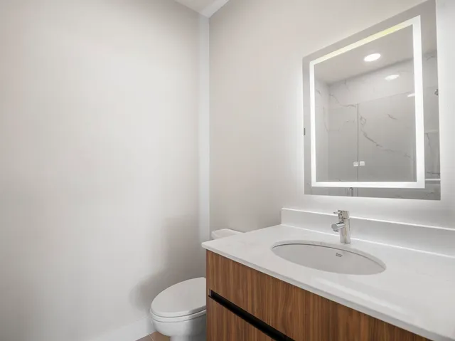 a bathroom with a toilet a sink and mirror