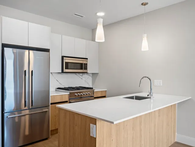 a kitchen with stainless steel appliances a refrigerator and a sink