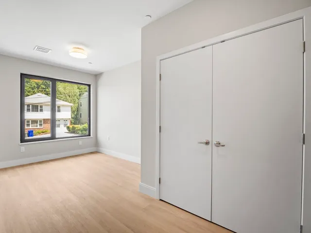 a view of an empty room with a window and a door
