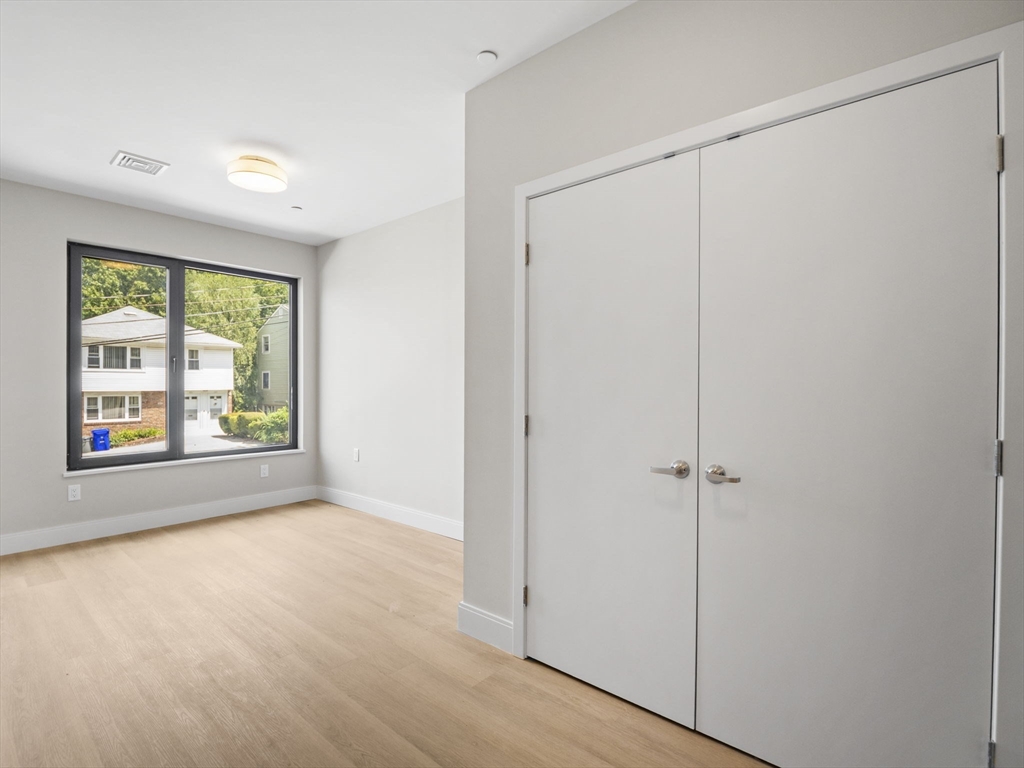 249 Corey Road, Unit 105 Boston, MA 02135 - Photo 22 of 39 a view of an empty room with a window and a door
