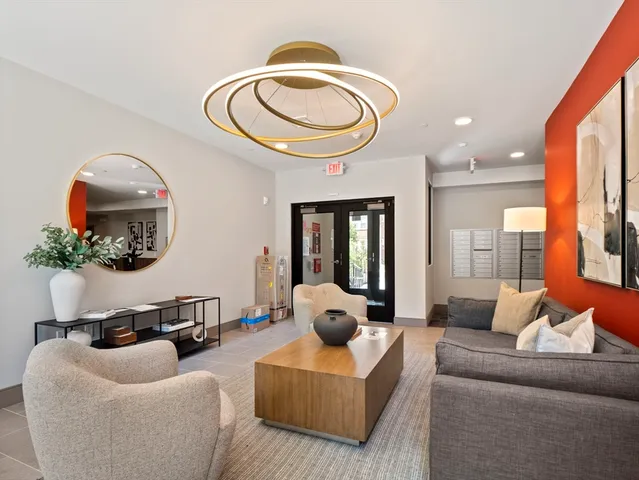 a living room with furniture a mirror and a large window