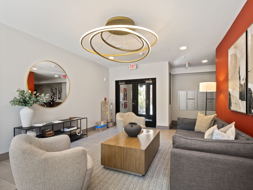 249 Corey Road, Unit 105 Boston, MA 02135 - Photo 29 of 39 a living room with furniture a mirror and a large window