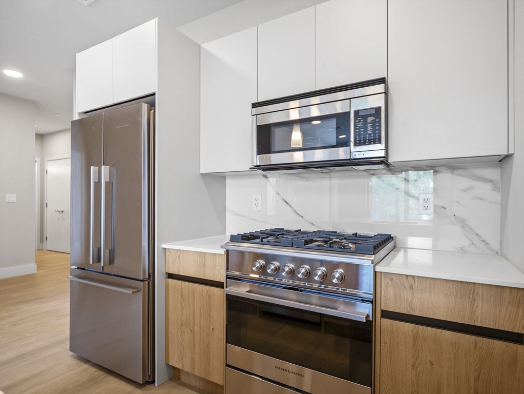 249 Corey Road, Unit 105 Boston, MA 02135 - Photo 3 of 39 a kitchen with a stove and a microwave