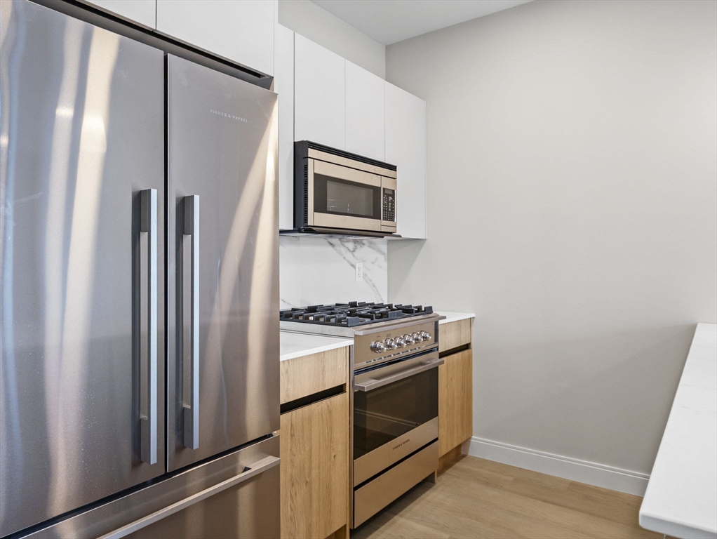 249 Corey Road, Unit 105 Boston, MA 02135 - Photo 4 of 39 a kitchen with a stove microwave and refrigerator