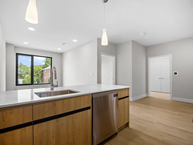 a kitchen with stainless steel appliances granite countertop a sink and a large window