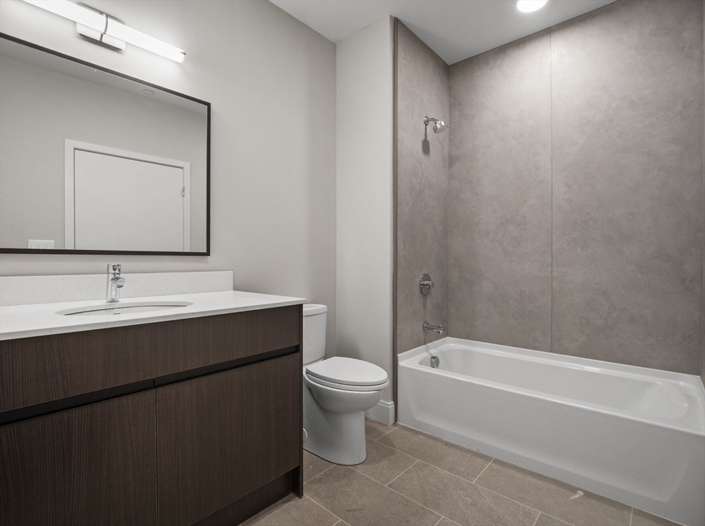 249 Corey Road, Unit 105 Boston, MA 02135 - Photo 7 of 39 a bathroom with a sink a toilet and shower