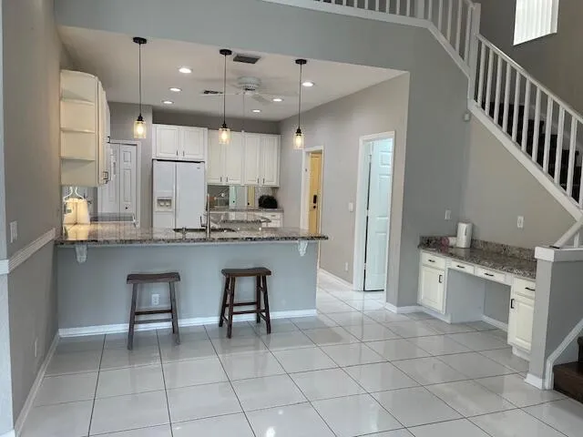 a large kitchen with a sink a counter top space stainless steel appliances and cabinets