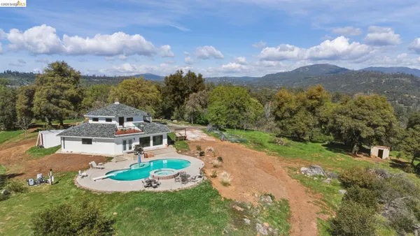 an aerial view of a house with a garden and trees