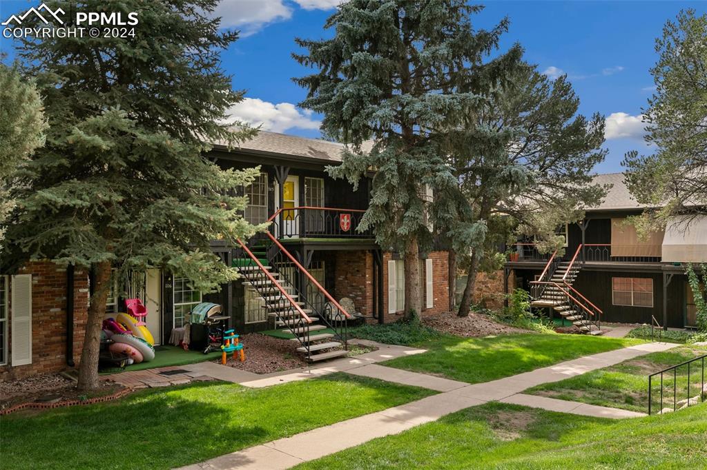 2902 Airport Road, Unit 215 Colorado Springs, CO 80910 - Photo 17 of 17 a view of a house with backyard and a tree