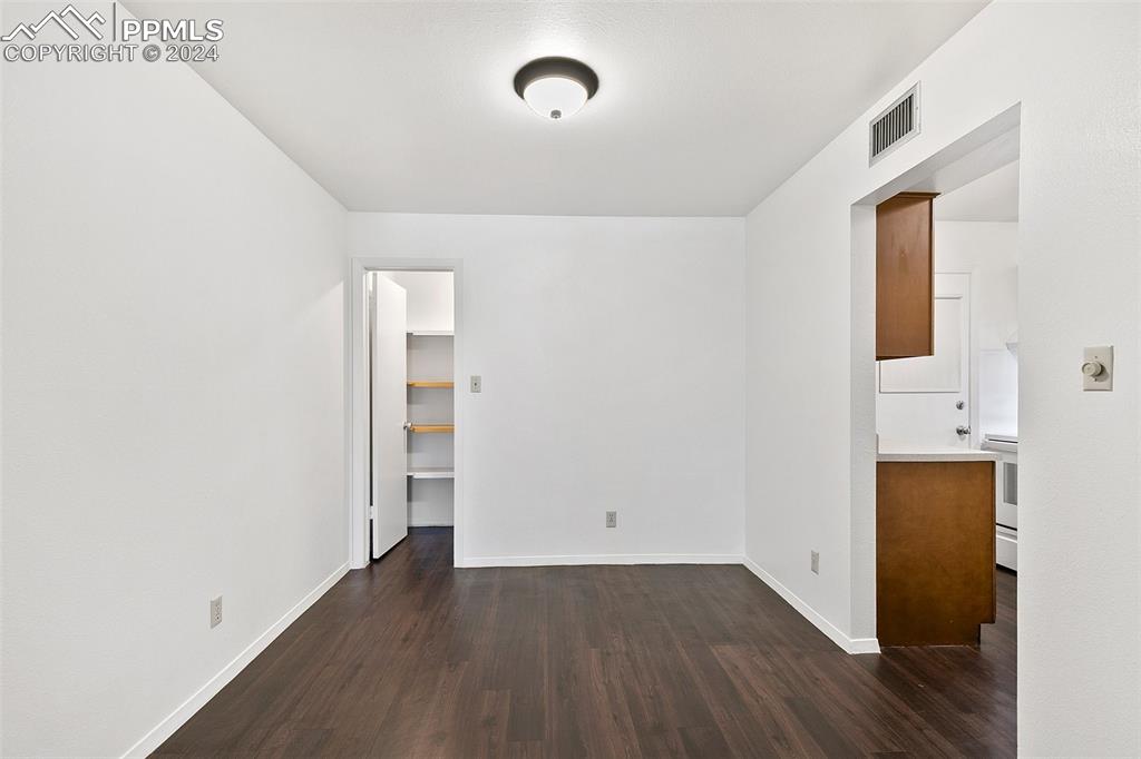 2902 Airport Road, Unit 215 Colorado Springs, CO 80910 - Photo 5 of 17 an empty room with wooden floor and windows