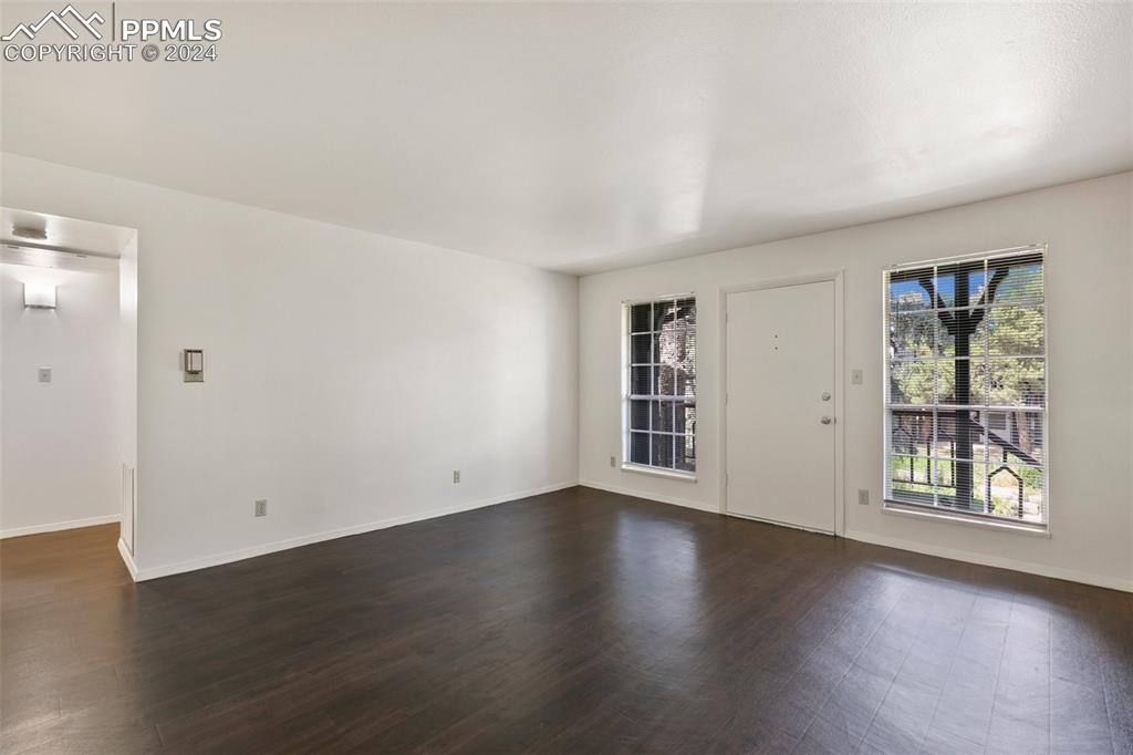 2902 Airport Road, Unit 215 Colorado Springs, CO 80910 - Photo 8 of 17 an empty room with wooden floor and windows