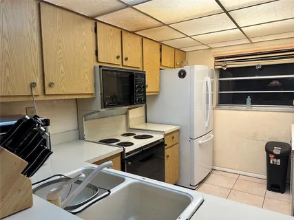 a kitchen with a refrigerator a stove top oven a sink and dishwasher