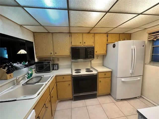 a kitchen with stainless steel appliances granite countertop a sink a stove a refrigerator and a refrigerator