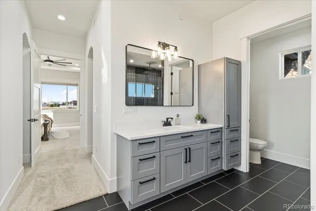 a spacious bathroom with a double vanity sink toilet mirror and bathtub