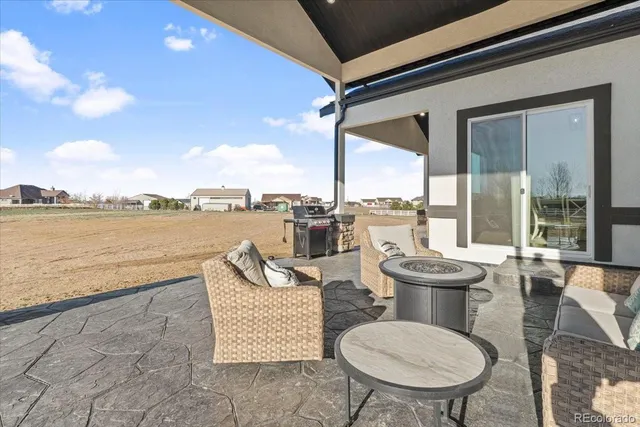 a view of a patio with couches chairs and wooden floor