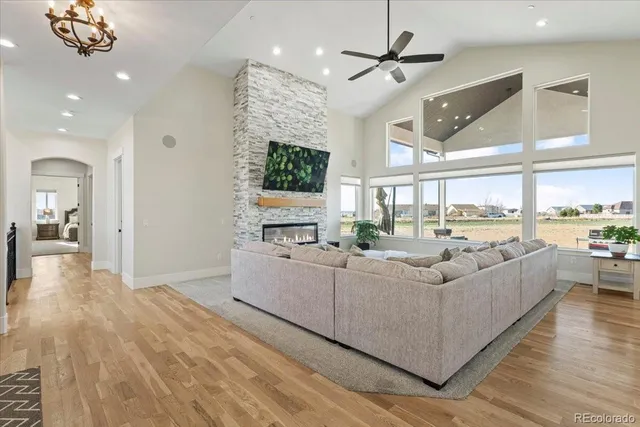 a living room with furniture kitchen view and a chandelier