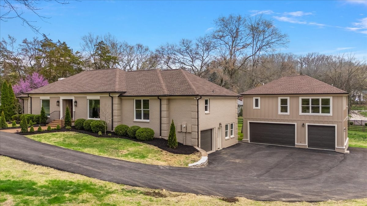1409 Sneed Road West Franklin, TN 37069 - Photo 2 of 63 a view of a yard in front of a house with plants and large tree