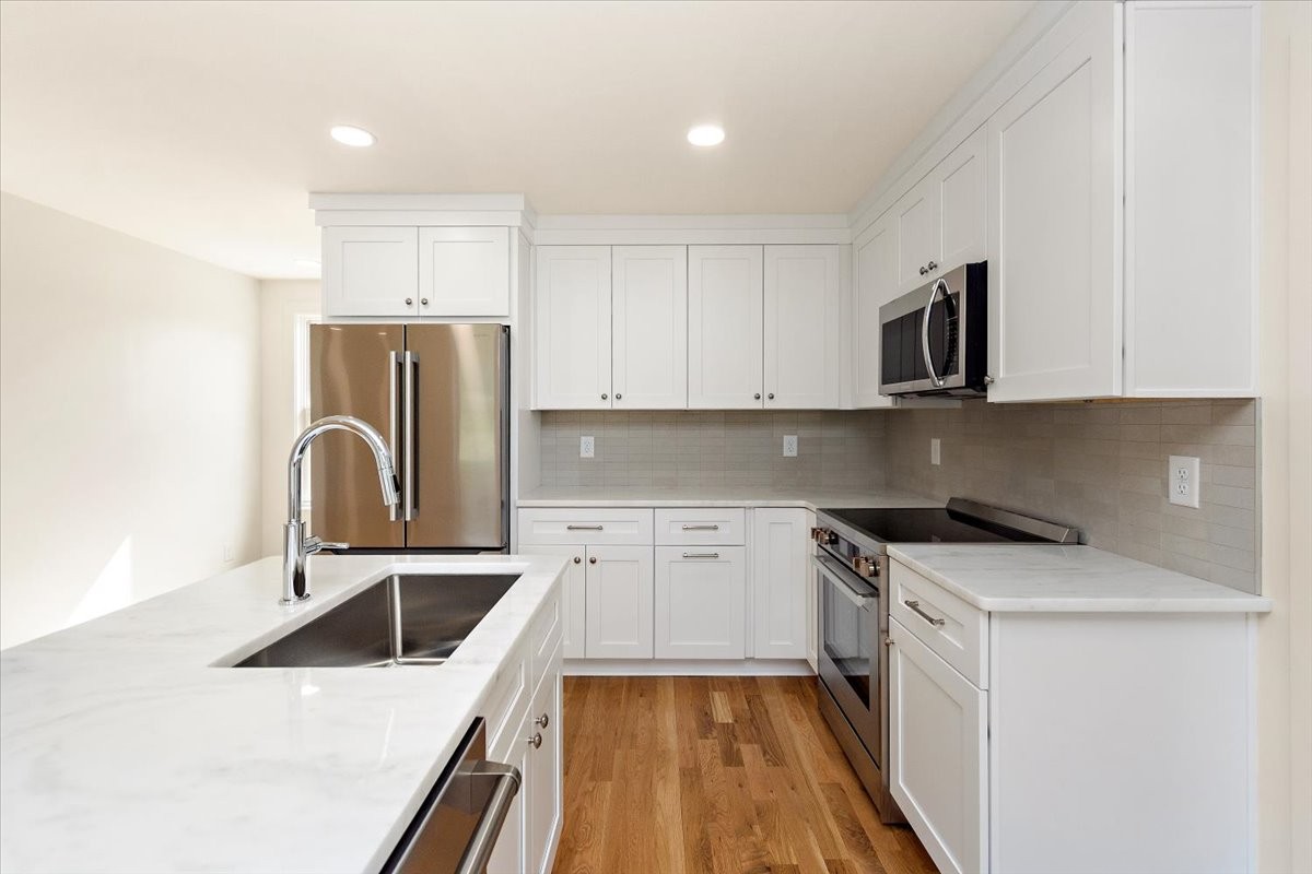 1409 Sneed Road West Franklin, TN 37069 - Photo 53 of 63 a kitchen with a sink a refrigerator and cabinets