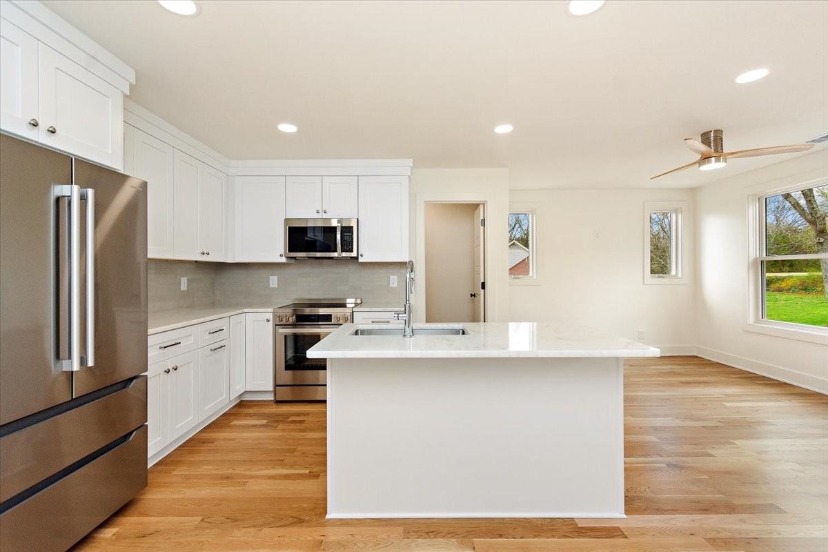 1409 Sneed Road West Franklin, TN 37069 - Photo 54 of 63 a large kitchen with stainless steel appliances granite countertop a stove a sink and a refrigerator