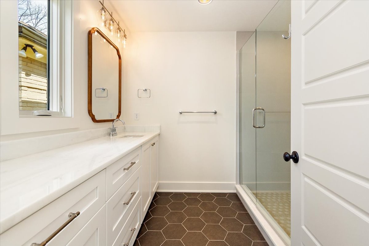 1409 Sneed Road West Franklin, TN 37069 - Photo 56 of 63 a bathroom with a granite countertop sink a mirror and a shower