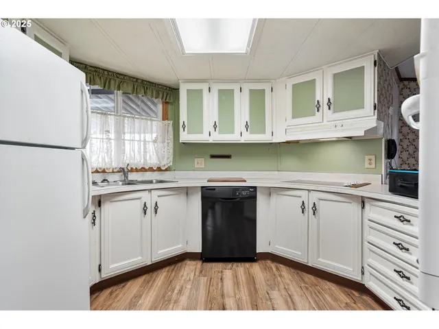 a kitchen with granite countertop a sink cabinets stainless steel appliances and a window