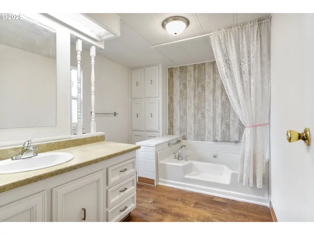 a bathroom with a tub sink and mirror