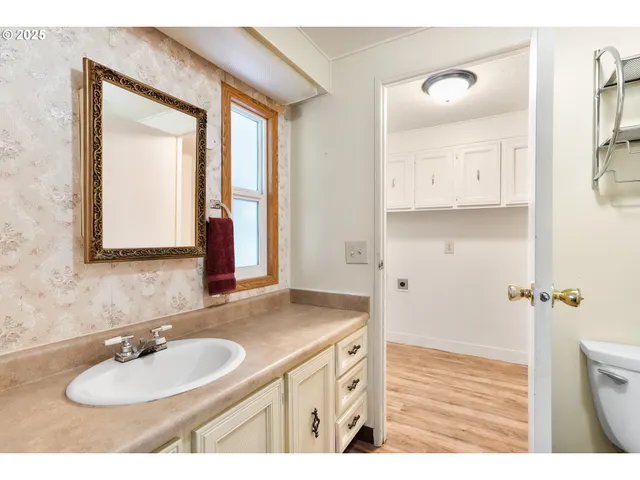 a bathroom with a sink vanity granite tub and a mirror