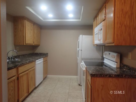 714 North Sanders Street Ridgecrest, CA 93555 - Photo 6 of 15 a kitchen with granite countertop a sink stove and refrigerator