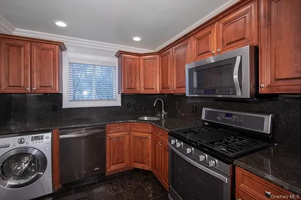 a kitchen with granite countertop a stove sink and cabinets