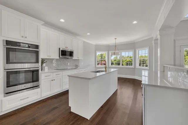 a kitchen with stainless steel appliances kitchen island granite countertop a stove a sink and a microwave