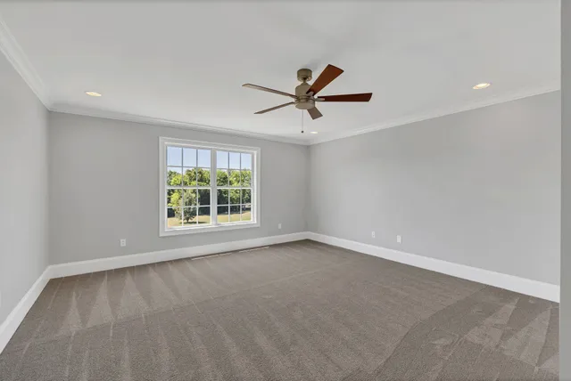 an empty room with closet and a ceiling fan