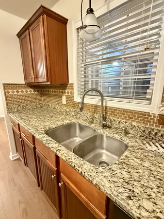 a kitchen with granite countertop a sink and a wooden cabinets