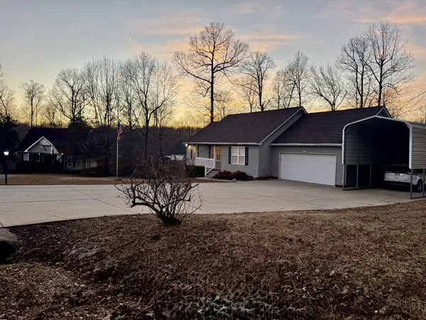 a view of a house with backyard and trees