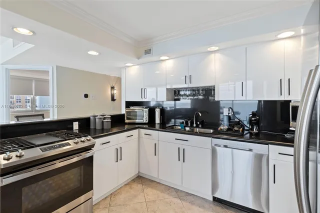 a kitchen with white cabinets and appliances