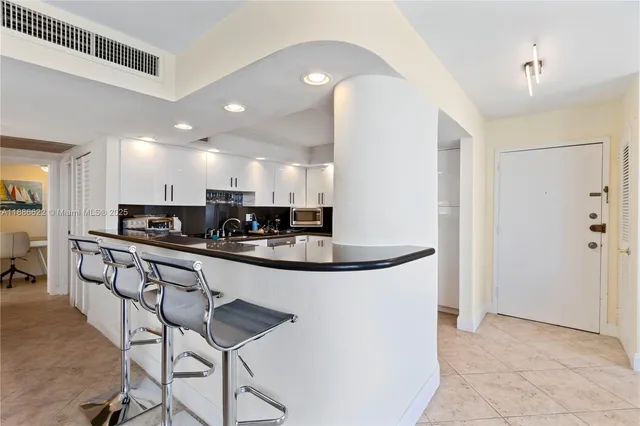 a kitchen with stainless steel appliances granite countertop a sink and a refrigerator