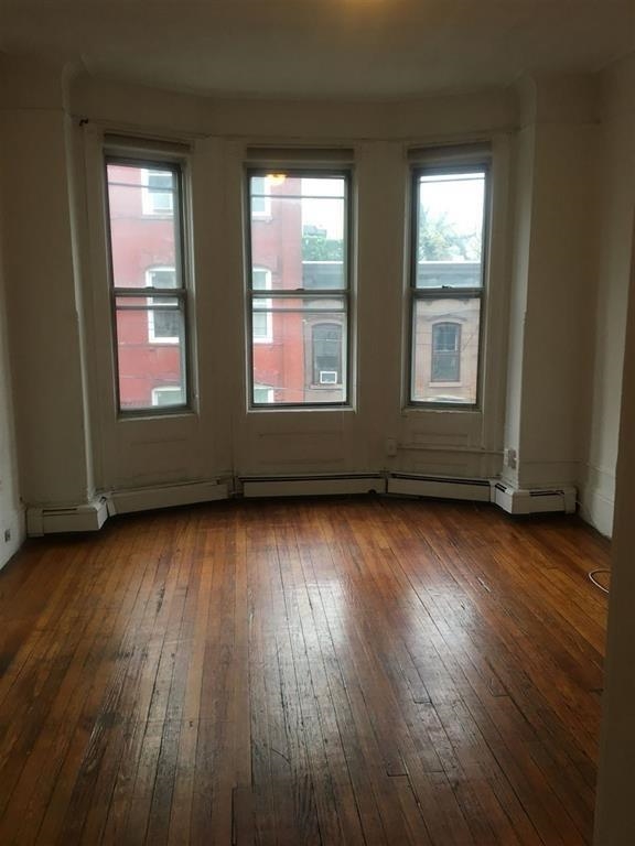 217 10th Street, Unit 2A Hoboken, NJ 07030 - Photo 1 of 4 an empty room with wooden floor and windows