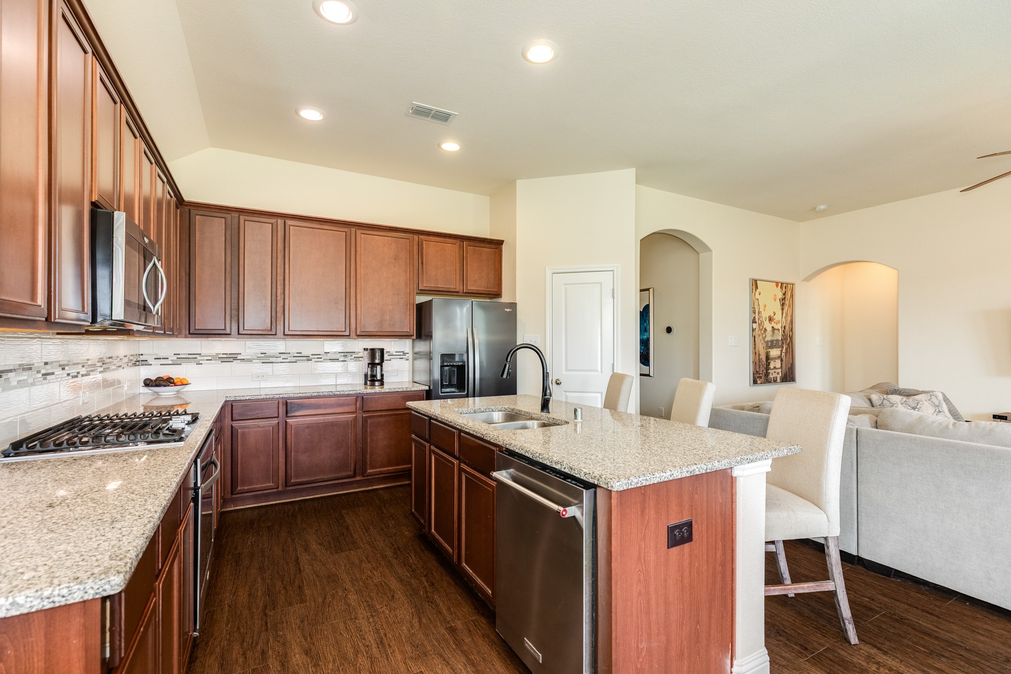 3519 Bay Drive Rosharon, TX 77583 - Photo 14 of 49 Chef's kitchen featuring elegant granite countertops, premium stainless steel appliances, abundant cabinet storage, and a stylish modern backsplash.