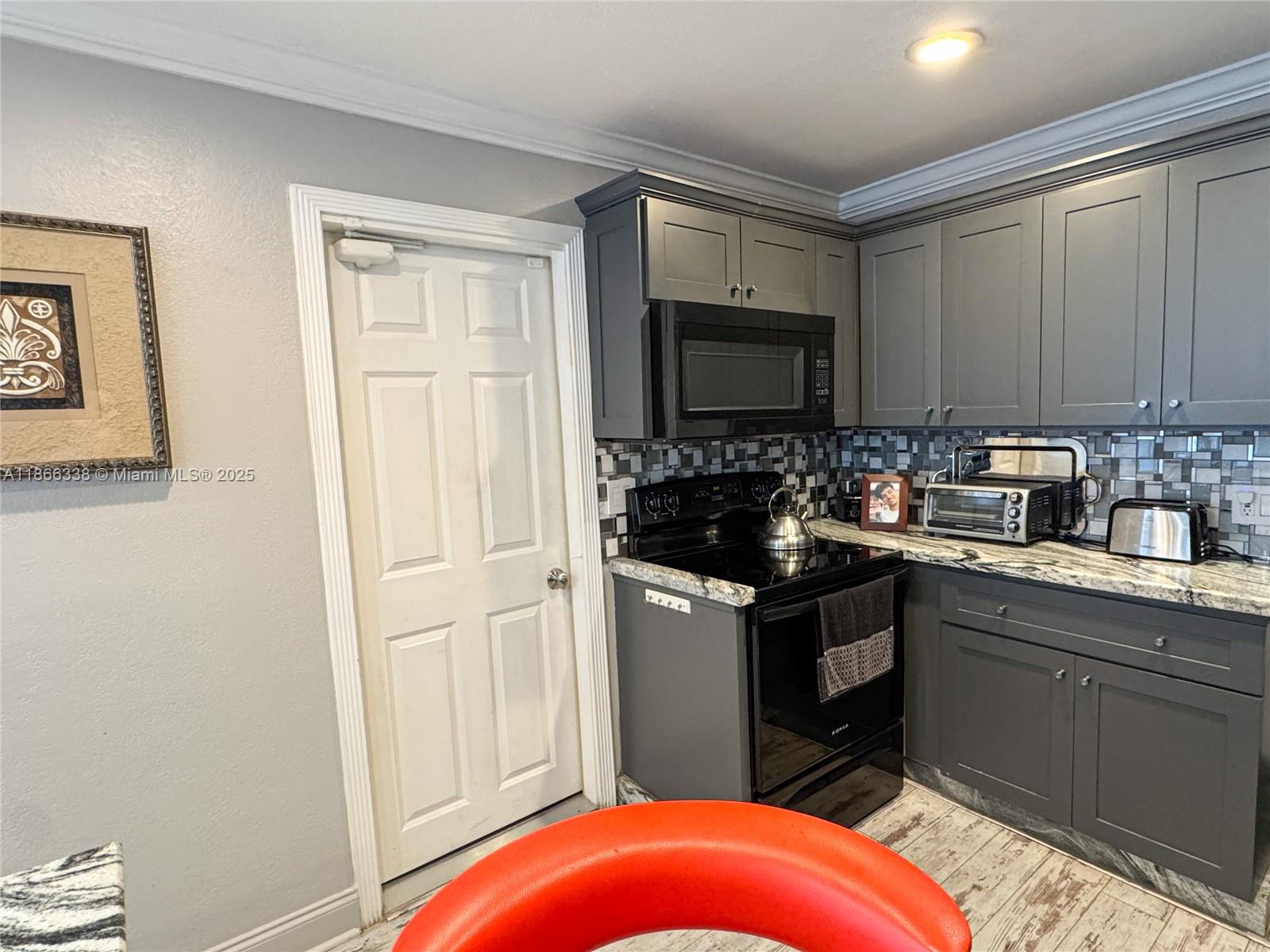 161 Northwest 27th Court Pompano Beach, FL 33064 - Photo 11 of 33 a kitchen with stainless steel appliances a stove a sink and a microwave