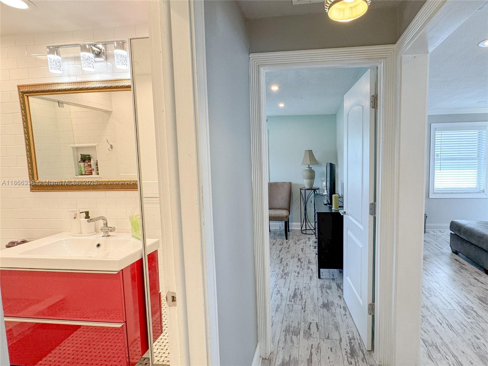 161 Northwest 27th Court Pompano Beach, FL 33064 - Photo 17 of 33 a en suite bathroom with a sink and mirror