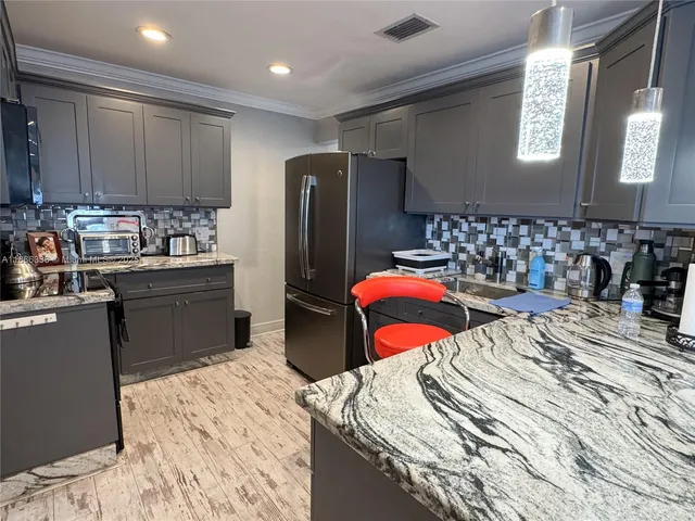 a kitchen with stainless steel appliances granite countertop a refrigerator and a sink