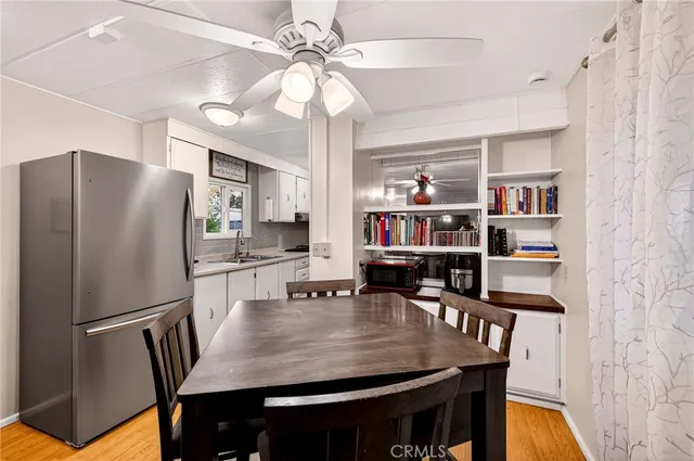 a kitchen with stainless steel appliances granite countertop a dining table chairs and refrigerator