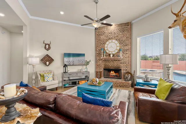 a living room with furniture a fireplace and a large window