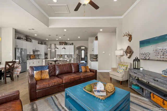 a living room with furniture kitchen view and a chandelier