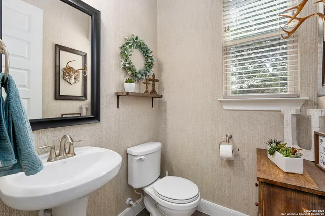 a bathroom with a toilet a sink and a mirror
